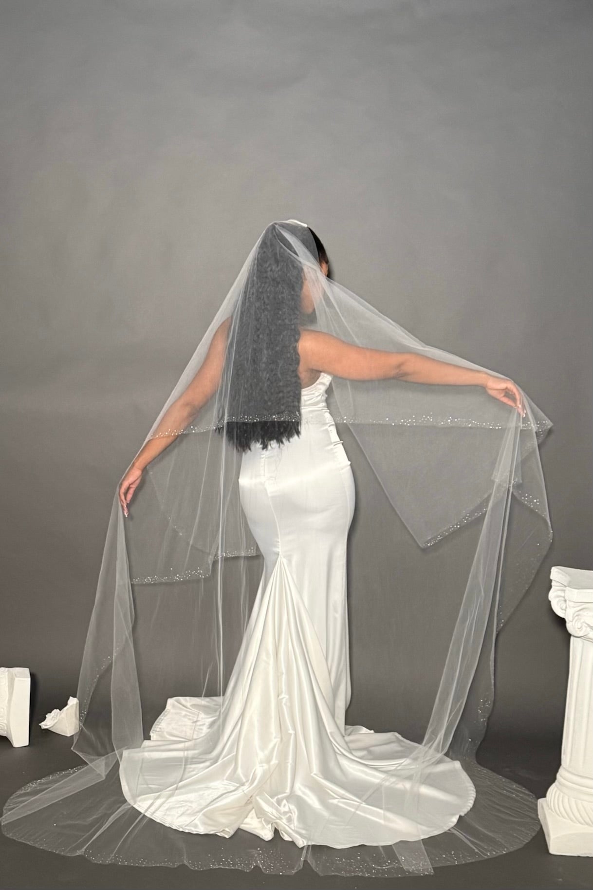 Model wearing handcrafted lightweight blusher veil with hundreds of crystallized dew drops on the entire trim. 