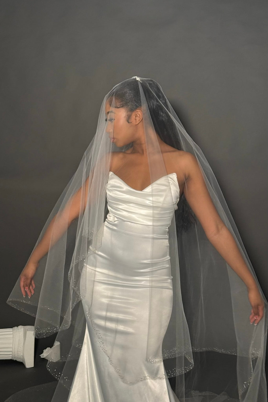 Model wearing cathedral veil with face covering. 